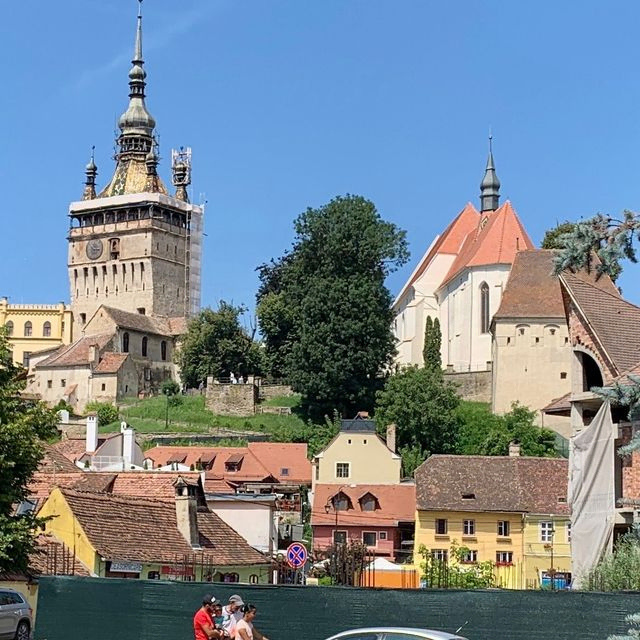 Uhrturm mit Blick auf eine Stadt mit bunten Dächern.