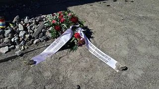 Kranz und Bänder auf Schotterboden.
