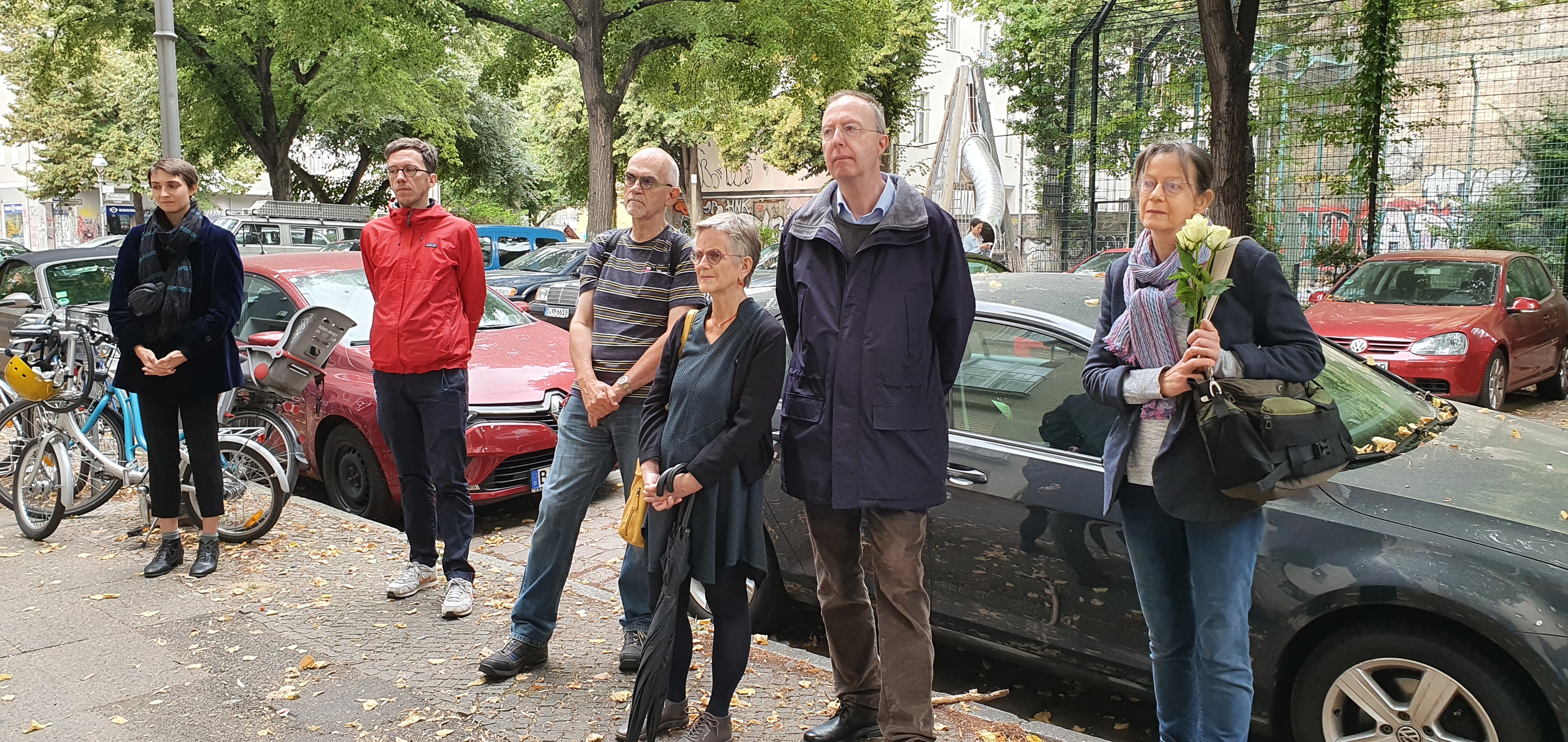 Gruppe von Menschen steht auf einem Bürgersteig in der Stadt.