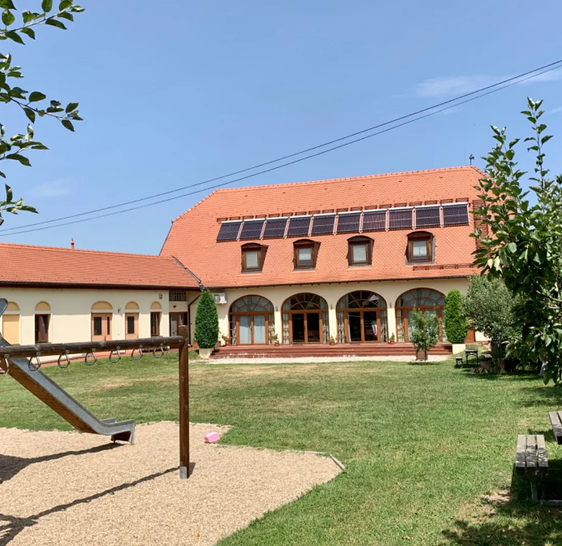 Gebäude mit Solarzellen und einem Spielplatz.